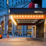 Photo of a hotel entrance and a waiting taxi cab in downtown Cleveland during the winter holidays.